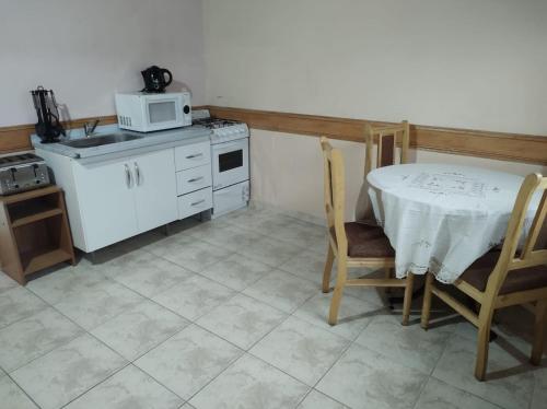 a small kitchen with a table and a microwave at Departamentos Paisaje del Beagle in Ushuaia