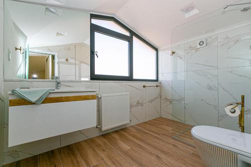 ein Badezimmer mit Waschbecken, Badewanne und Fenster in der Unterkunft Paradise Town Villa Estella in Belek