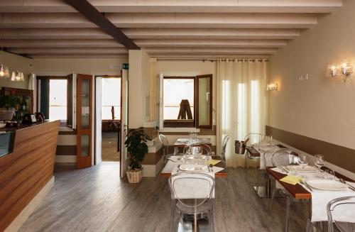ein Restaurant mit Tischen und Stühlen in einem Zimmer in der Unterkunft Locanda Stravedo in Pellestrina
