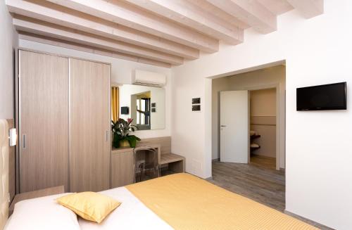 a bedroom with a bed and a tv on a wall at Locanda Stravedo in Pellestrina