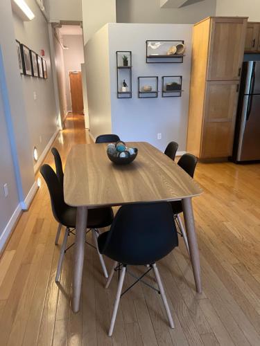 a dining room table with chairs and a refrigerator at Downtown Norfolk Loft in Norfolk