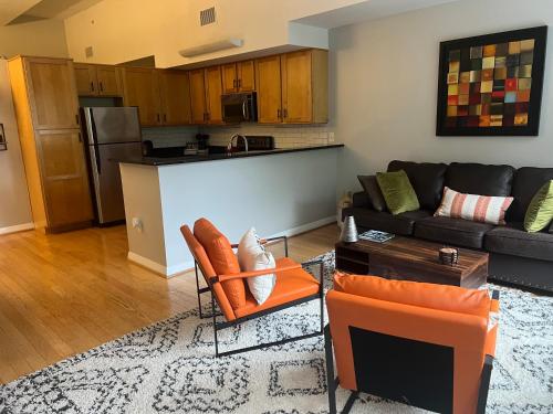 a living room with a couch and a kitchen at Downtown Norfolk Loft in Norfolk