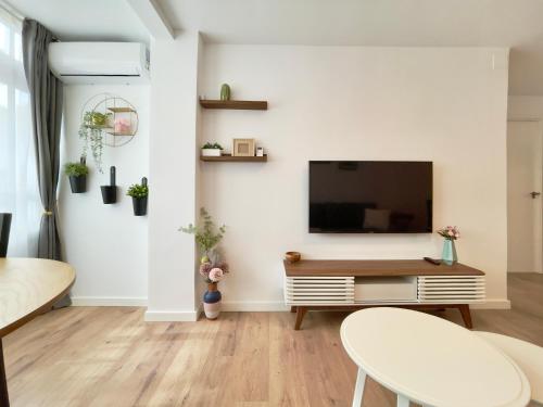 salon z telewizorem z płaskim ekranem na białej ścianie w obiekcie Casita del Puerto 2 w mieście Santa Pola