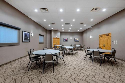 a conference room with tables and chairs and a screen at Comfort Inn The Pointe in Niagara Falls