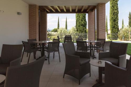 a restaurant with tables and chairs and a patio at Hotel Relais Agli Olivi in Lazise