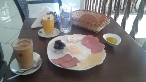 una mesa con un plato de comida y bebidas. en NOUARA Appart'hotel, en Chefchaouen