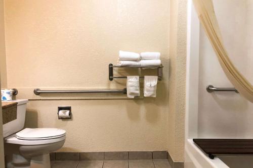 a bathroom with a toilet and towels at Quality Inn I-70 at Wanamaker in Topeka