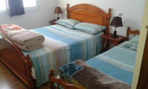 NOUARA Appart'hotel في شفشاون: غرفة نوم بسريرين عليها مناشف