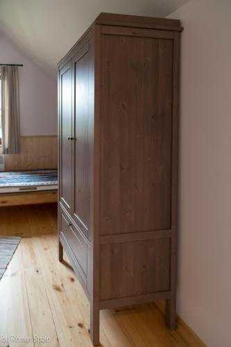 a wooden cabinet is against a wall in a room at Kaszubska Odskocznia Ostoja Bukowo in Borowy Młyn