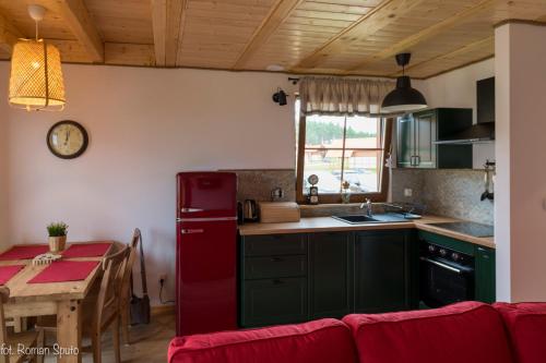 a kitchen with a red refrigerator next to a table at Kaszubska Odskocznia Ostoja Bukowo in Borowy Młyn