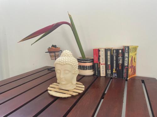 a table with a statue of a head and books at Twenty4 Hostel in Paramaribo