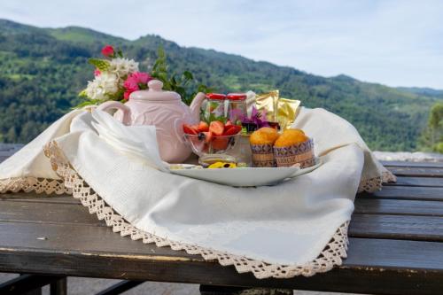 a tray of fruit and a tea set on a bench at Carvalheira Country House - Gerês in Braga