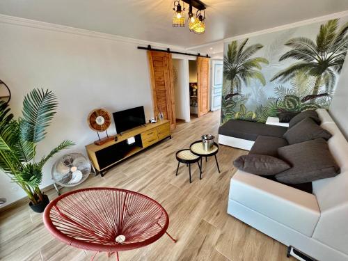 a living room with a couch and a table at Ti kaz COCO DOUCEUW sea view in Sainte-Anne