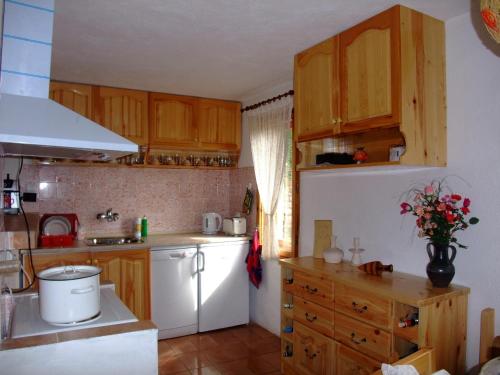 a kitchen with wooden cabinets and a white refrigerator at СПА къща за гости Каза Роза - Swiss Style Chalet Casa Rosa SPA Guest House in Kyustendil