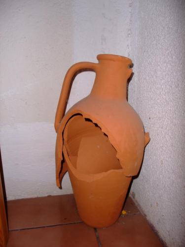 an orange vase sitting next to a wall at СПА къща за гости Каза Роза - Swiss Style Chalet Casa Rosa SPA Guest House in Kyustendil