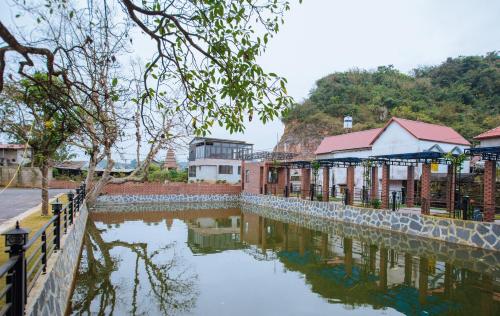 un groupe de bâtiments à côté d'une masse d'eau dans l'établissement Emopea Moc Chau, à Mộc Châu