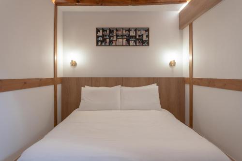 a small bedroom with a bed with white sheets at Luxury hanok with private bathtub - SW10 in Seoul