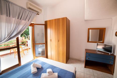 a bedroom with a bed and a tv and a window at Perfect House in Pefkochori