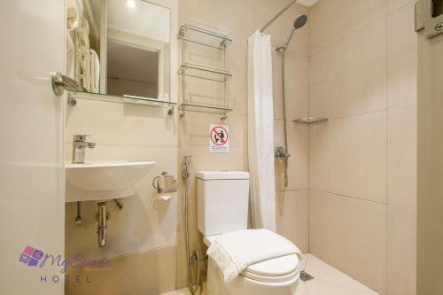 a small bathroom with a toilet and a sink at MySpace Hotel @BGC in Manila