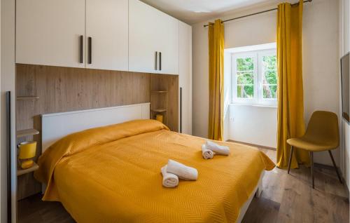 拉賓的住宿－Beautiful Home In Labin With 2 Bedrooms, Wifi And Outdoor Swimming Pool，一间卧室配有黄色的床和毛巾