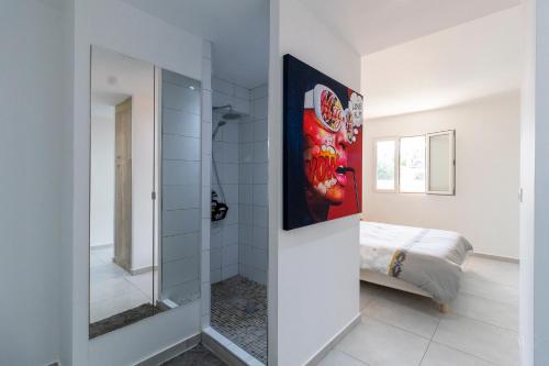 a bathroom with a glass shower and a bed at Java Paradise in Anse Marcel 