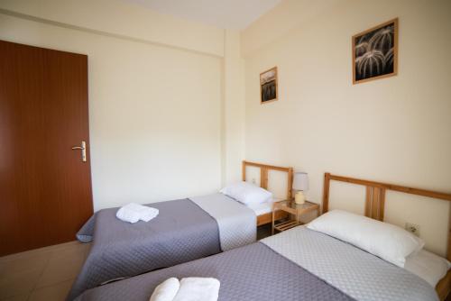 two beds in a hotel room with towels at Perfect Apartment in Nea Potidaea