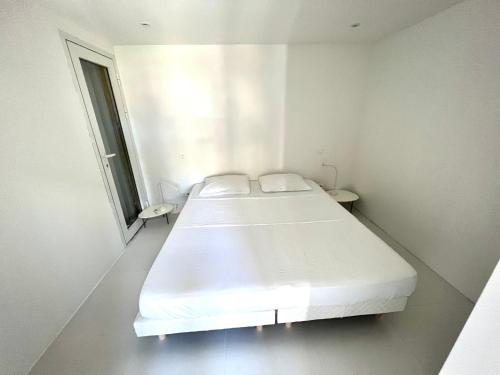 a white room with two beds and a window at Bungalow for 6 people maximum at Saint Barth in Gustavia