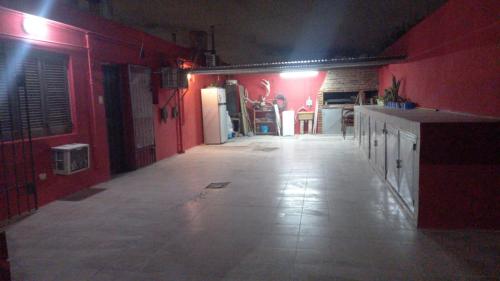 una cocina con paredes rojas y un pasillo largo en Apart La Mochita en San Fernando del Valle de Catamarca