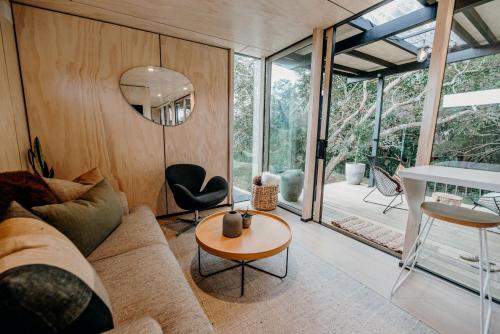 a living room with a couch and a table at Blackwood Cabin in Raglan