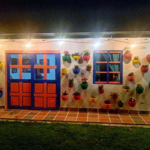 a house with colorful doors and potted plants on the wall at Génesis, un lugar para descansar y disfrutar in Santa Elena