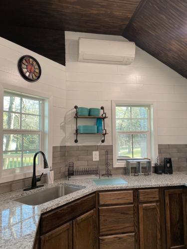 a kitchen with a sink and a clock on the wall at Cozy Cabin in Crestwood Subdivision in Avinger