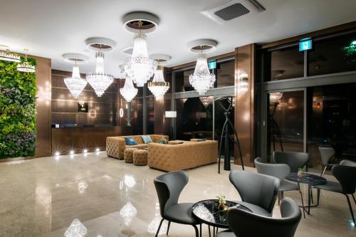 a living room with a couch and chairs and chandeliers at Daon Hotel in Jeonju
