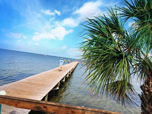 a man walking on a wooden pier over the water at Little Harbor #205 the place to stay in Ruskin