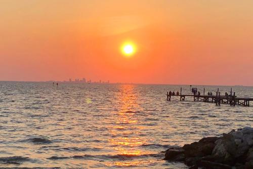 a sunset over a body of water with a pier at Little Harbor #205 the place to stay in Ruskin