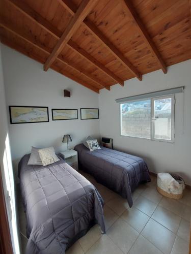 um quarto com 2 camas e uma grande janela em Alarken em Ushuaia