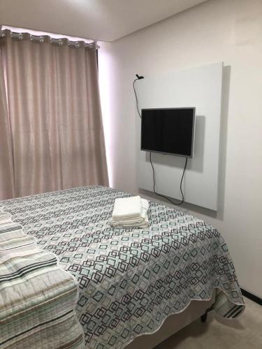 a bedroom with a bed and a flat screen tv at FLAT BEIRA MAR BARRA DE JANGADA ANDAR ALTO JABOATão in Recife