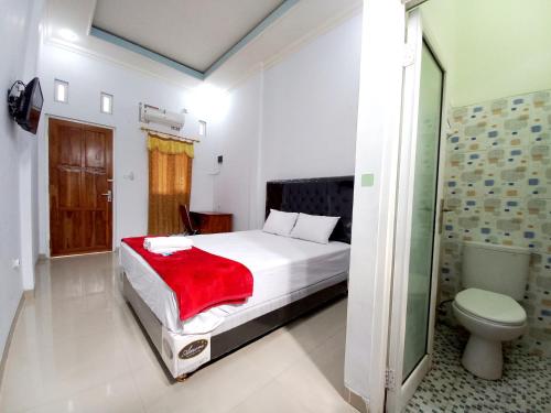 a bedroom with a bed and a toilet in it at Harmony House Syariah near Alun Alun Pati Mitra RedDoorz in Pati