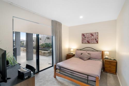 a bedroom with a bed and a sliding glass door at Port Out, Starboard Home in Tranmere