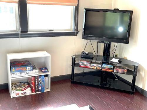 a tv on a stand with a shelf with books at Gorgeous Ski On/Off 2 BR Sleeps 8 Jiminy-Must See Luxury in Hancock