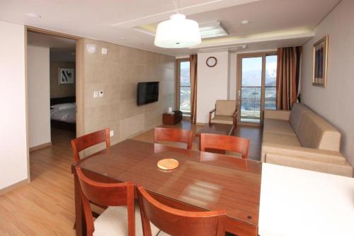 a dining room and living room with a table and chairs at High1 Condominium in Jeongseon