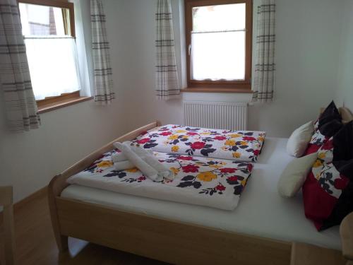 ein kleines Schlafzimmer mit einem Bett mit Blumenbettdecke in der Unterkunft Stübilerhof in St. Johann im Ahrntal