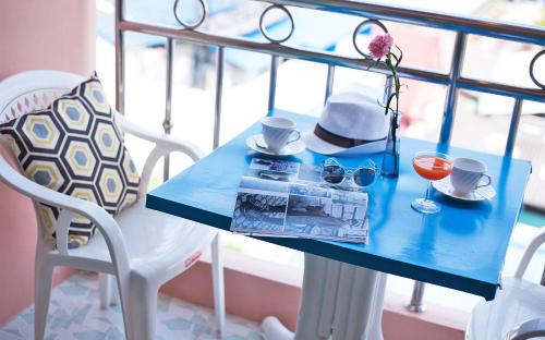 a blue table with a drink and a hat and glasses at Thipurai City Hotel in Hua Hin