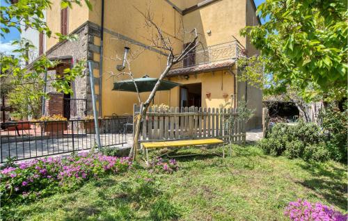 a yellow bench in front of a building with flowers at 1 Bedroom Cozy Home In Montegiovi in Montegiovi