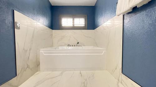 La salle de bains est pourvue d'un lavabo blanc et de murs bleus. dans l'établissement The Fremont Inn, à Monterey