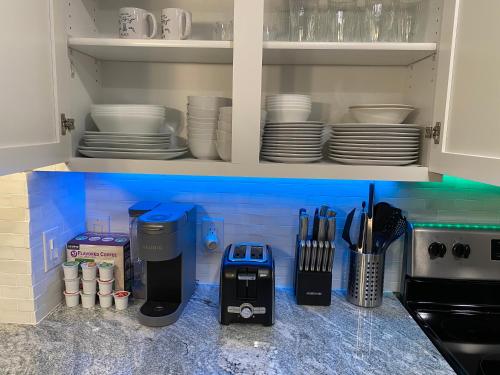 a kitchen counter with a coffee maker and plates at Waterfront Hernando beach house on deep water canal w/dock, fishing, kayak in Hernando Beach