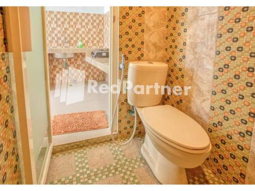 a bathroom with a toilet and a shower at Griya Rahayu Guesthouse Mitra RedDoorz near Jatim Park 2 Batu in Tlekung