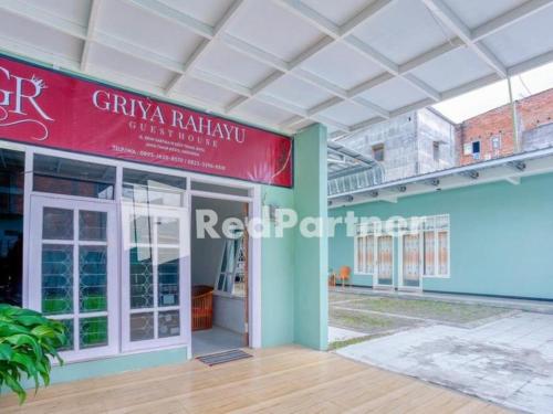 a building with a red sign on the side of it at Griya Rahayu Guesthouse Mitra RedDoorz near Jatim Park 2 Batu in Tlekung