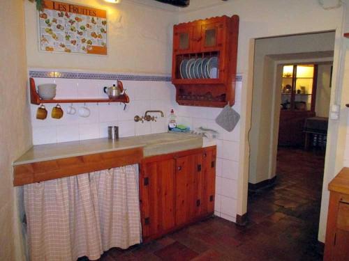 una cocina con armarios de madera y fregadero en Can Corretjola, en Navata