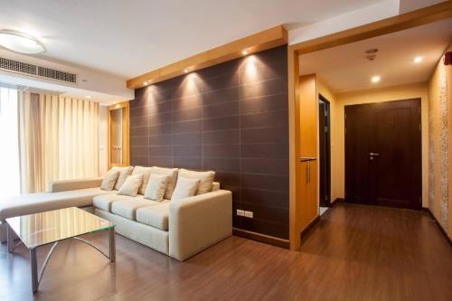 a living room with a couch and a wall at 5A-Short-term rental allowed-2BRs Downtown Bangkok in Makkasan