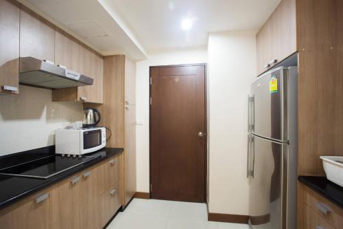 a small kitchen with a microwave and a refrigerator at 5A-Short-term rental allowed-2BRs Downtown Bangkok in Makkasan